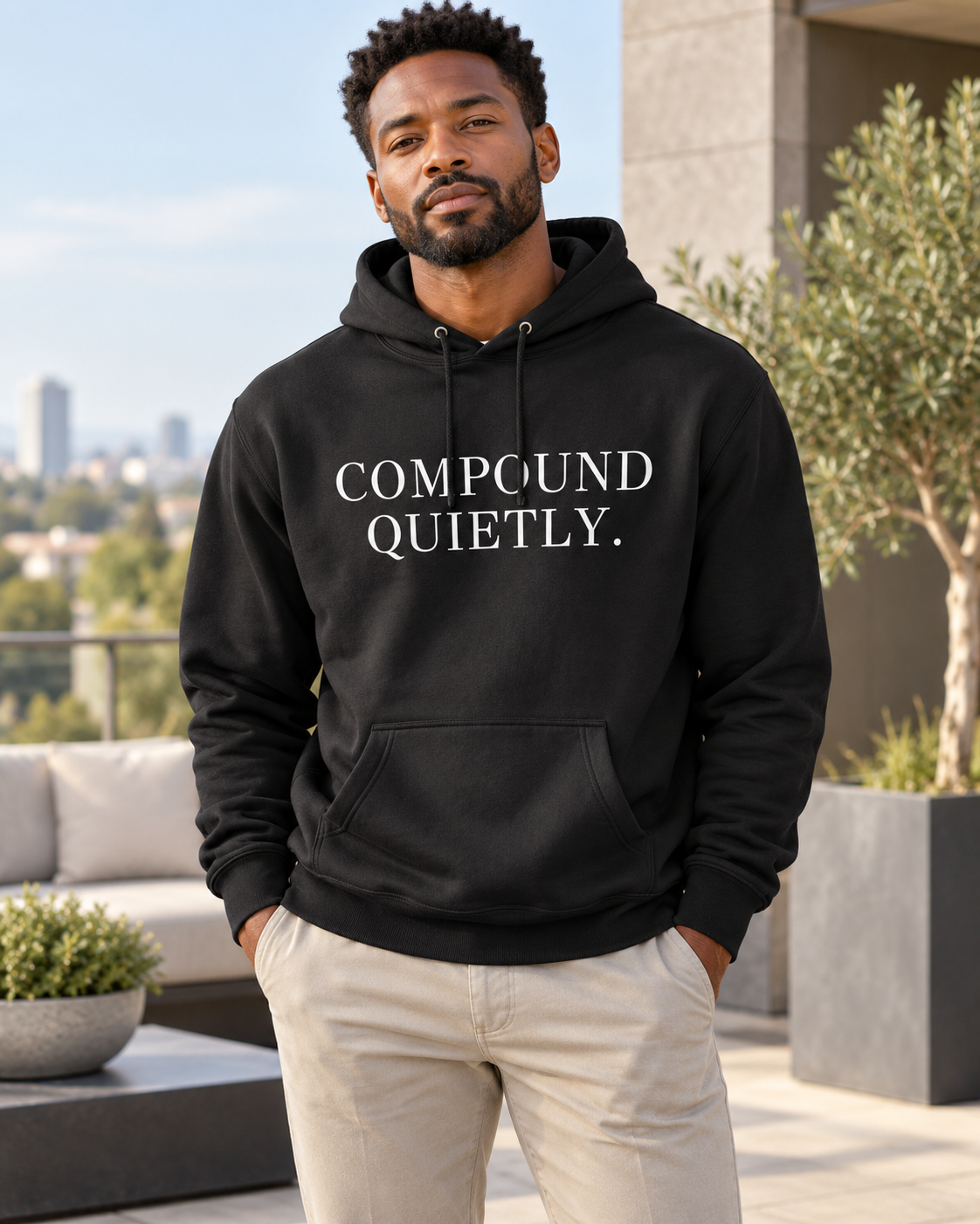 Compound Quietly™ Hoodie in black, front, worn on a terrace